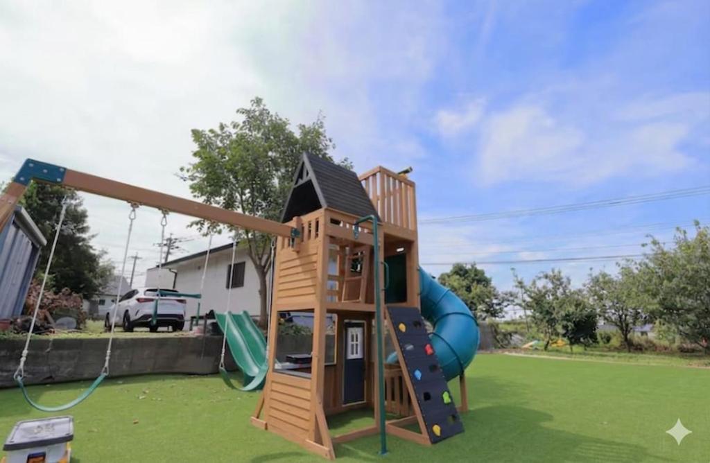 a playground with a slide in a yard at Dino Base in Mifune