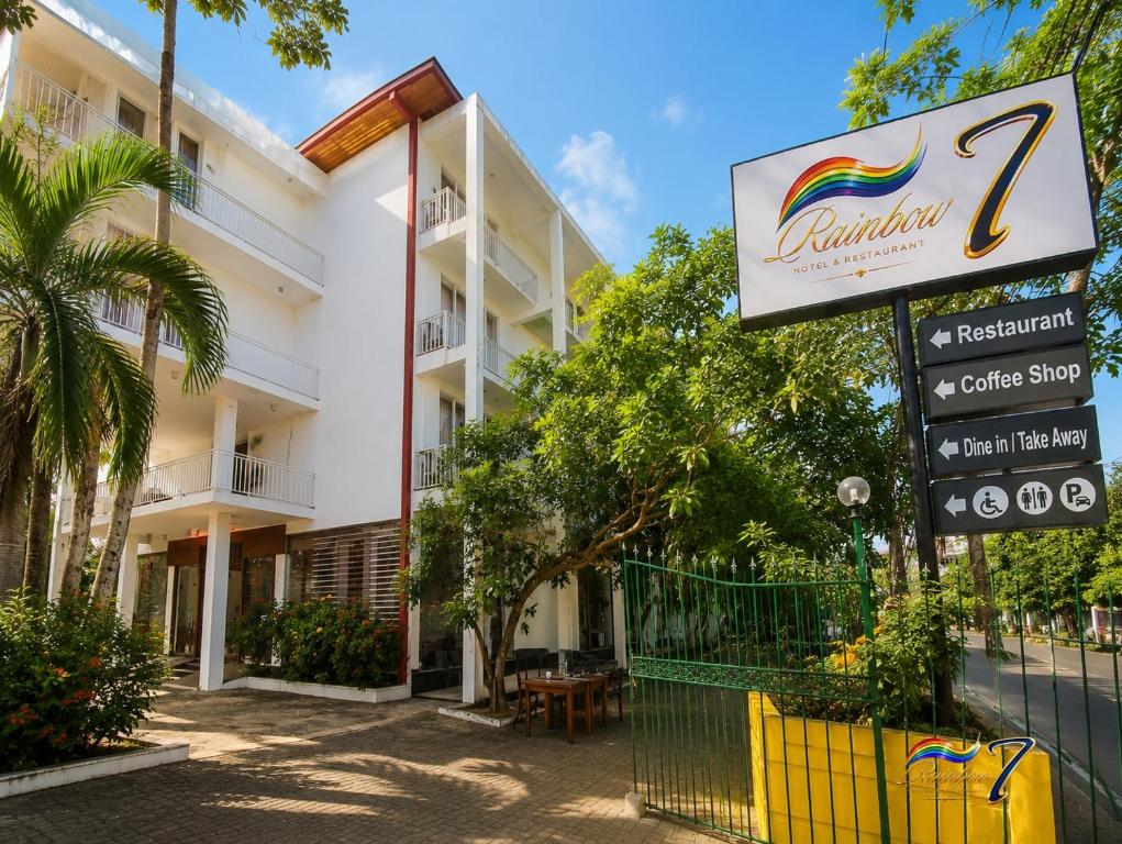 a building with a sign for a hotel at Rainbow Seven Hotel in Negombo