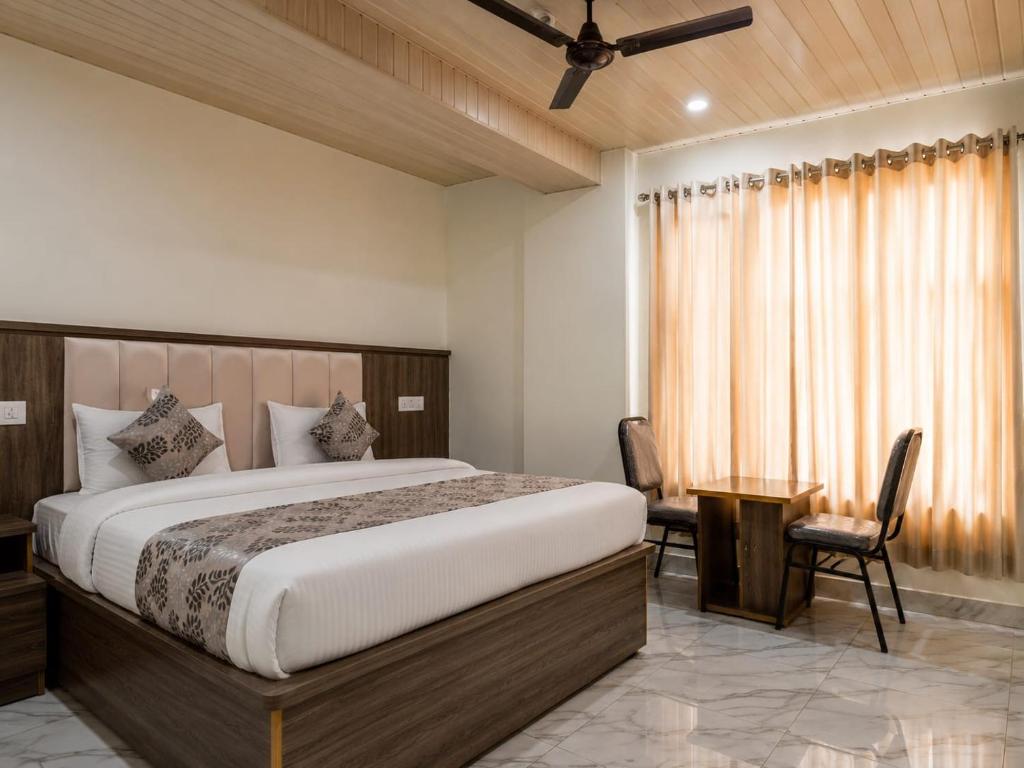 a bedroom with a large bed and a desk at The white range in Baijnāth