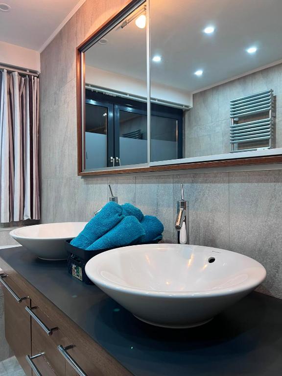 a bathroom with two white sinks and a mirror at Modernes City Apartment 8km Red Bull Ring in Knittelfeld