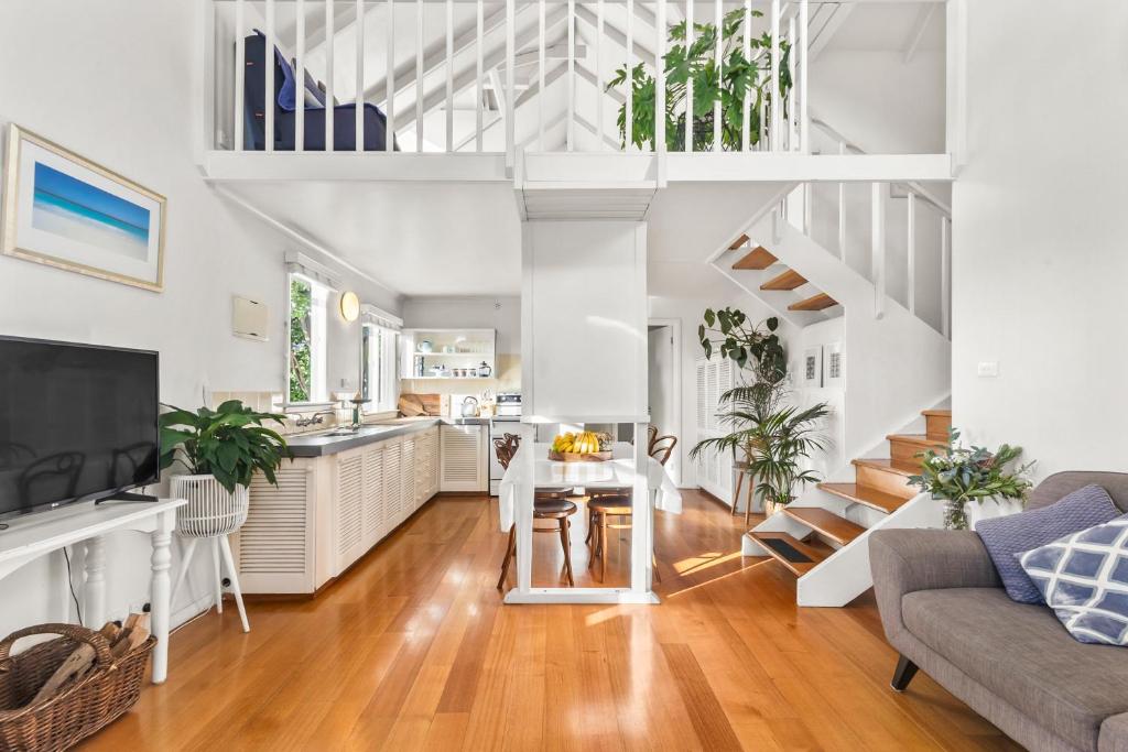 a kitchen and living room with white walls and wooden floors at The Stables - Charming Loft with Derwent River Views in Sandy Bay