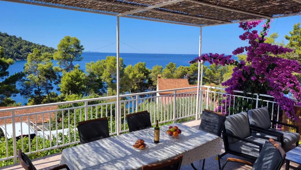 a table on a balcony with a view of the water at Apartman Arijeta Korčula in Smokvica