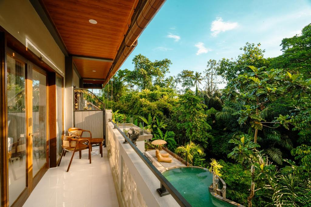 an outdoor balcony with a bath tub and trees at Arcana Ubud in Ubud