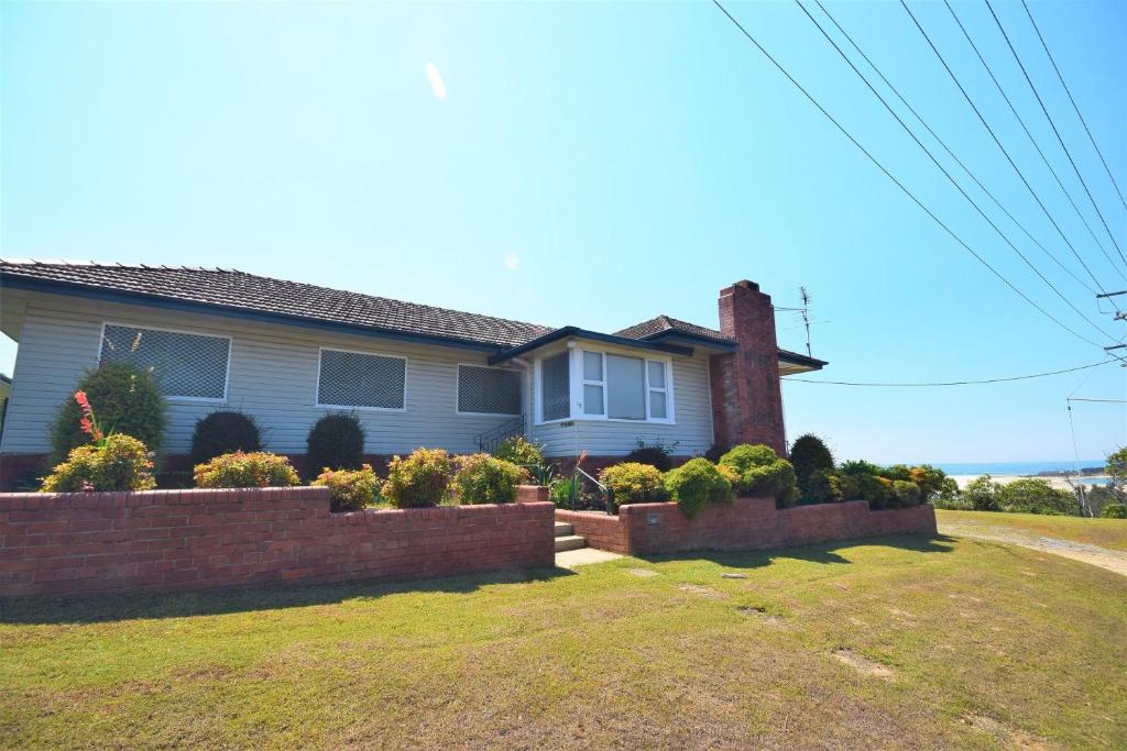 a house with a brick fence in front of a yard at 13 High Street in Nambucca Heads