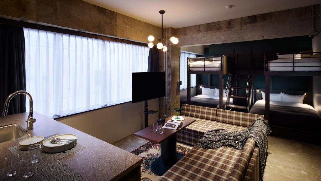 a living room with a couch and bunk beds at SHIFT HOTEL Shibuya Jinnan in Tokyo