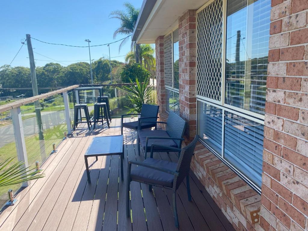 a deck with chairs and tables on a building at 59 Short in Nambucca Heads