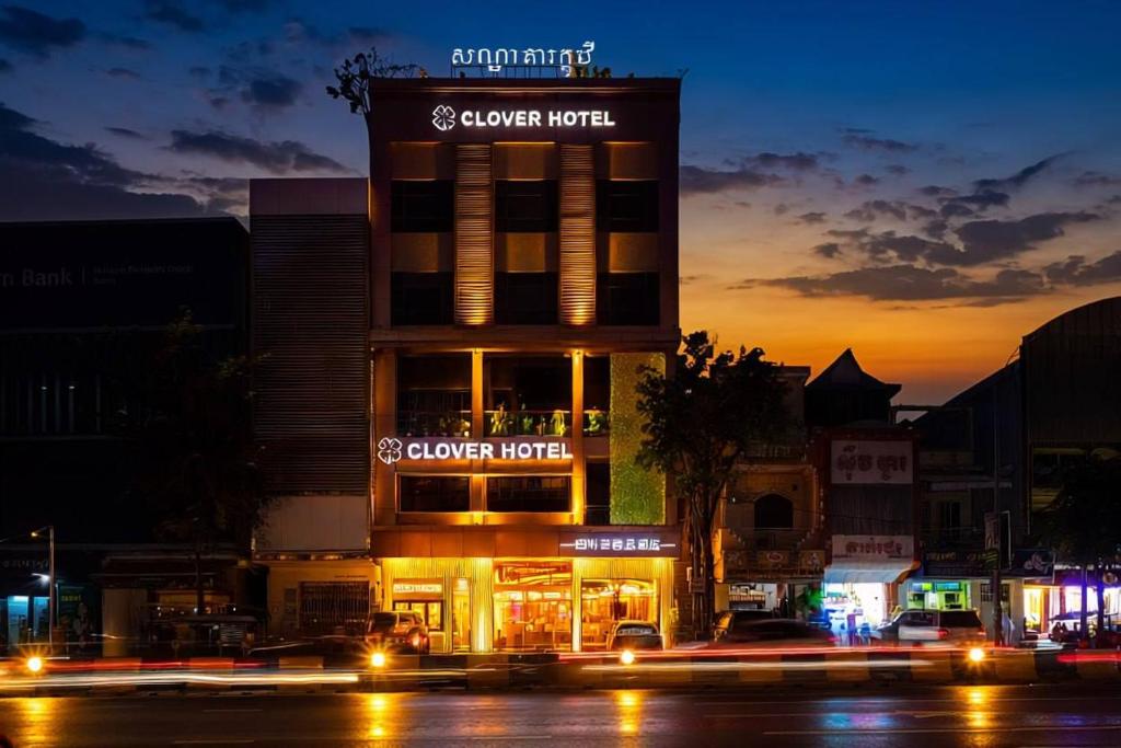 a building with a sign on top of it at night at CLOVER HOTEL MONIVONG By LEE in Phnom Penh