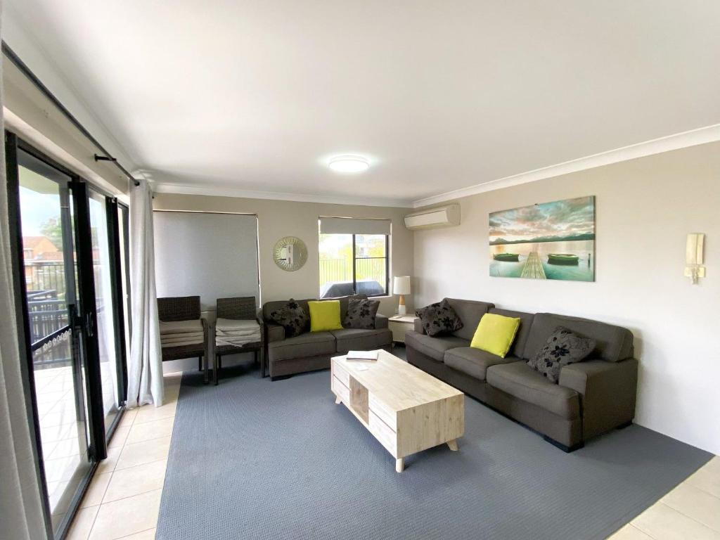 a living room with a couch and a coffee table at Karingal in Nambucca Heads