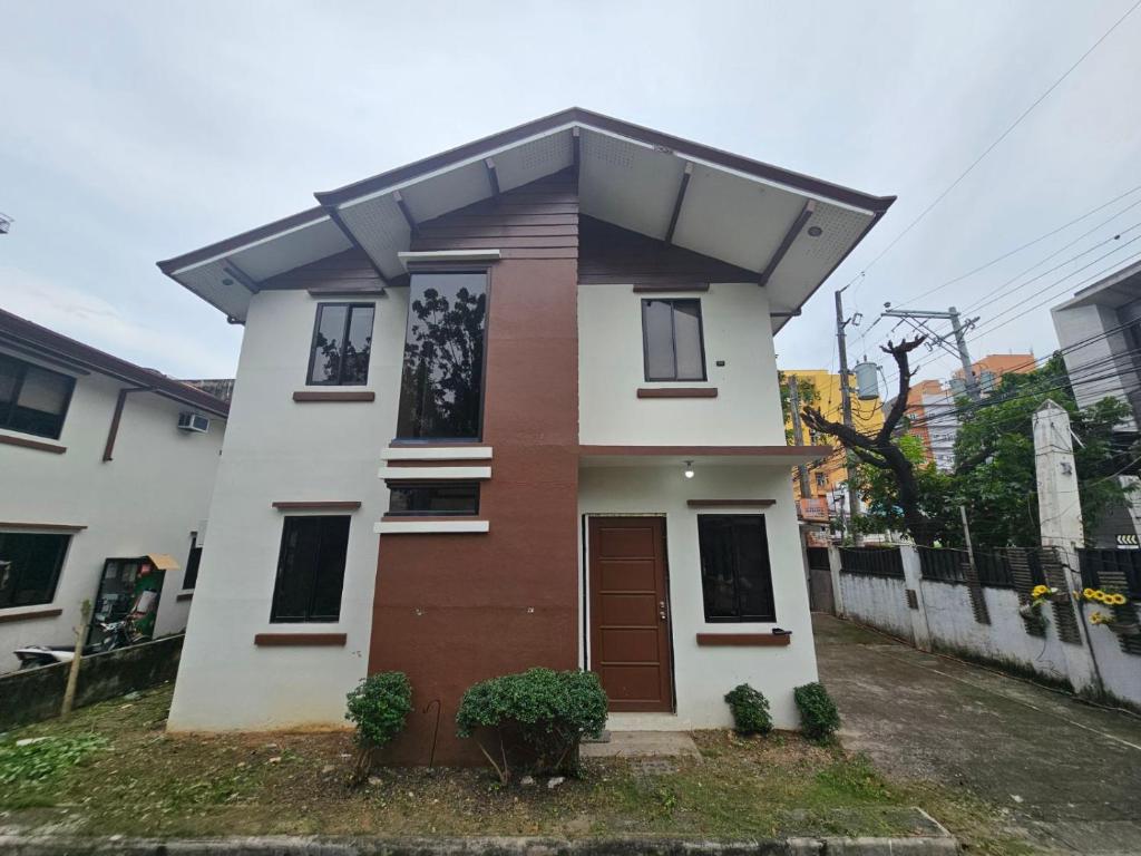 a small house with a brown door on a street at Kasa Boutique Residence in Cebu City