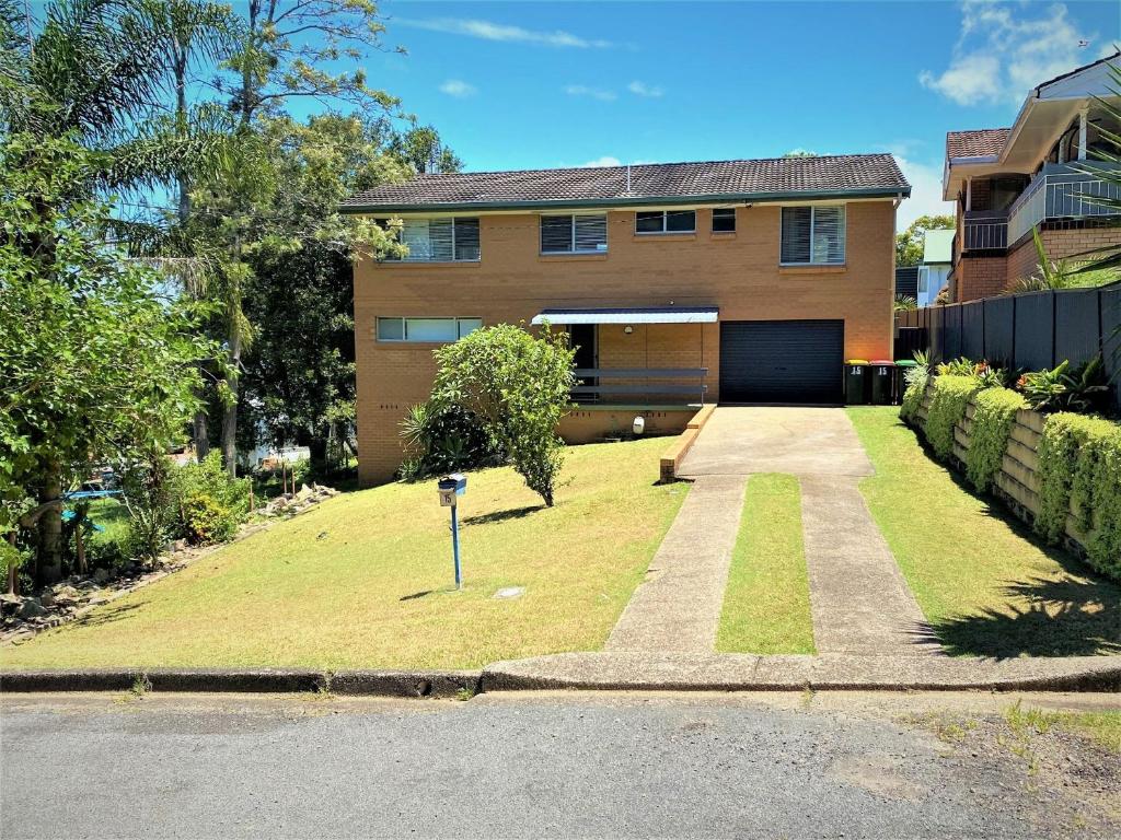 a house with a garage and a grass yard at Riverwood in Nambucca Heads
