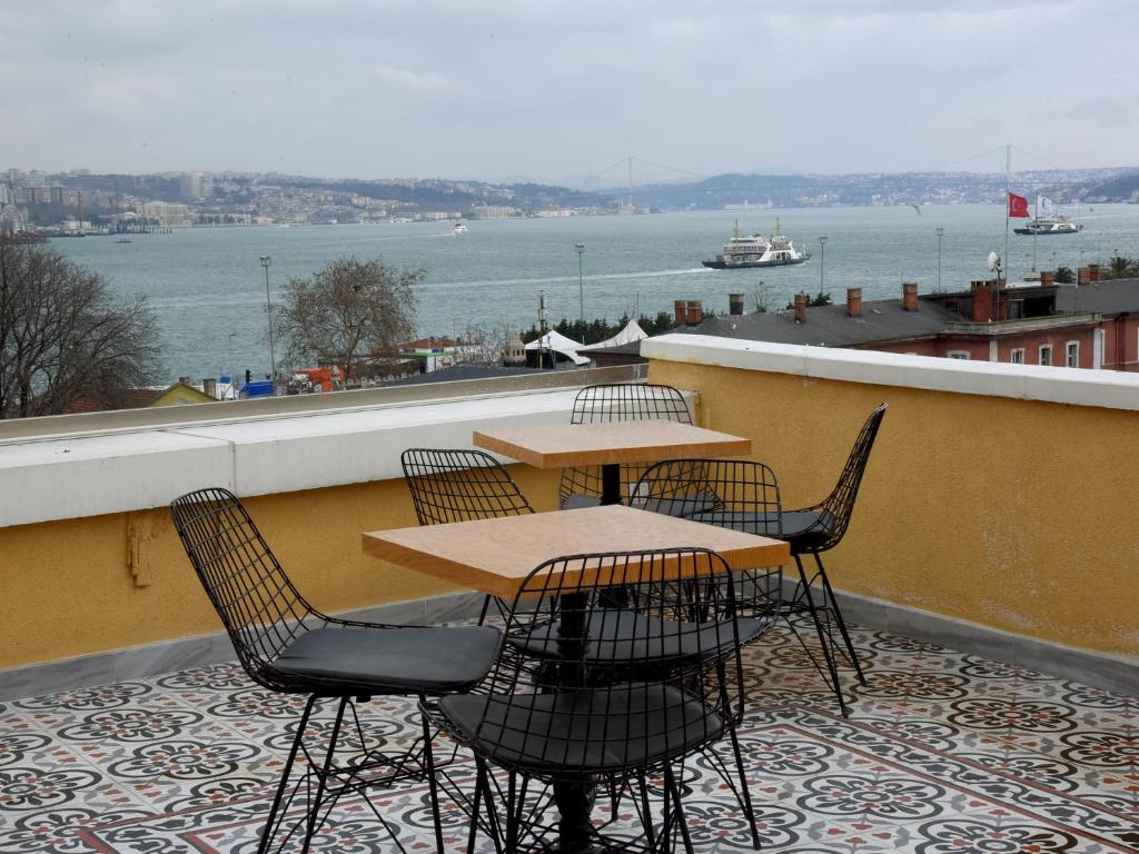 a table and chairs on a balcony with a view of the water at İstasyon Hotel in Istanbul