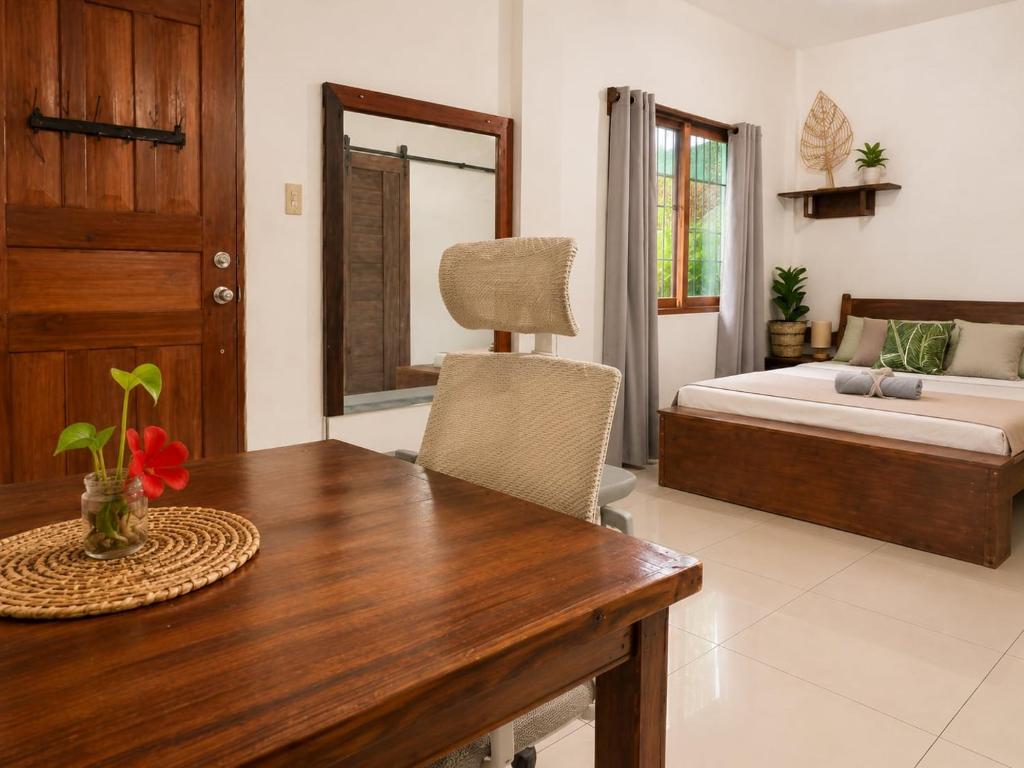 a living room with a table and a bed and a bedroom at Pascoe's Units Siargao- Suites in General Luna