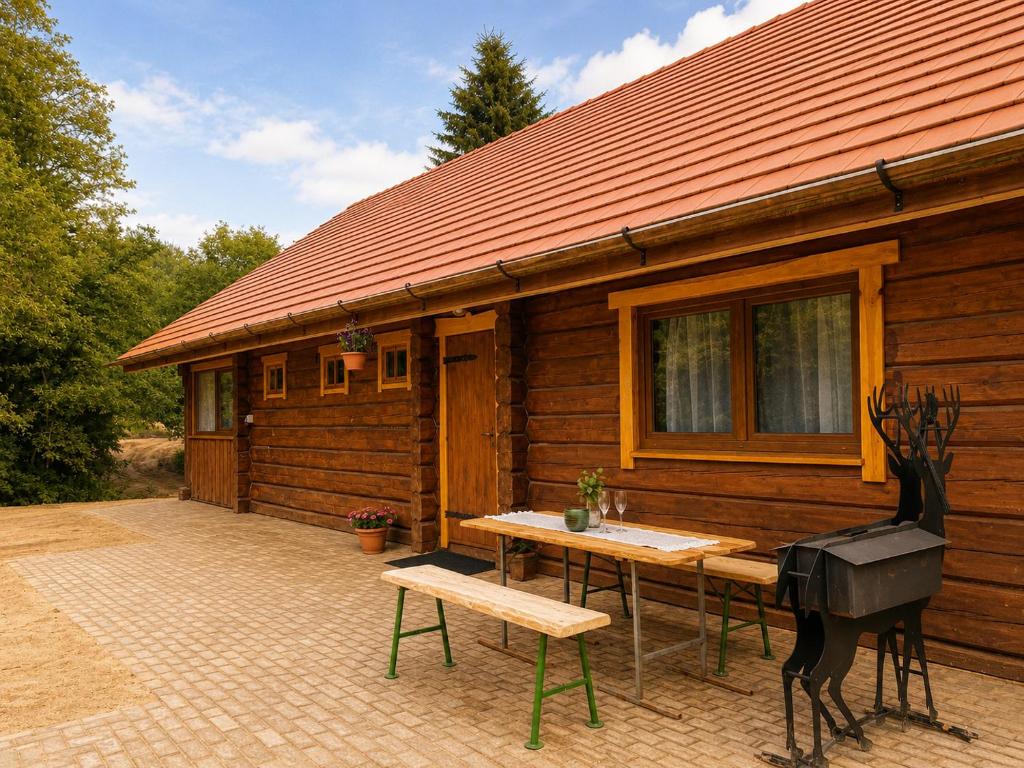 a wooden cabin with a table and a statue in front of it at Privaatne maja metsas, kraanist voolab allikavesi in Plaani