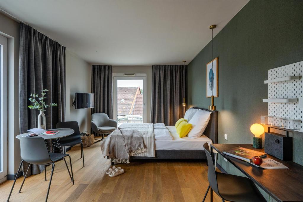 a bedroom with a bed and a table and chairs at ipartment Wolfsburg HOME by Best Western in Wolfsburg