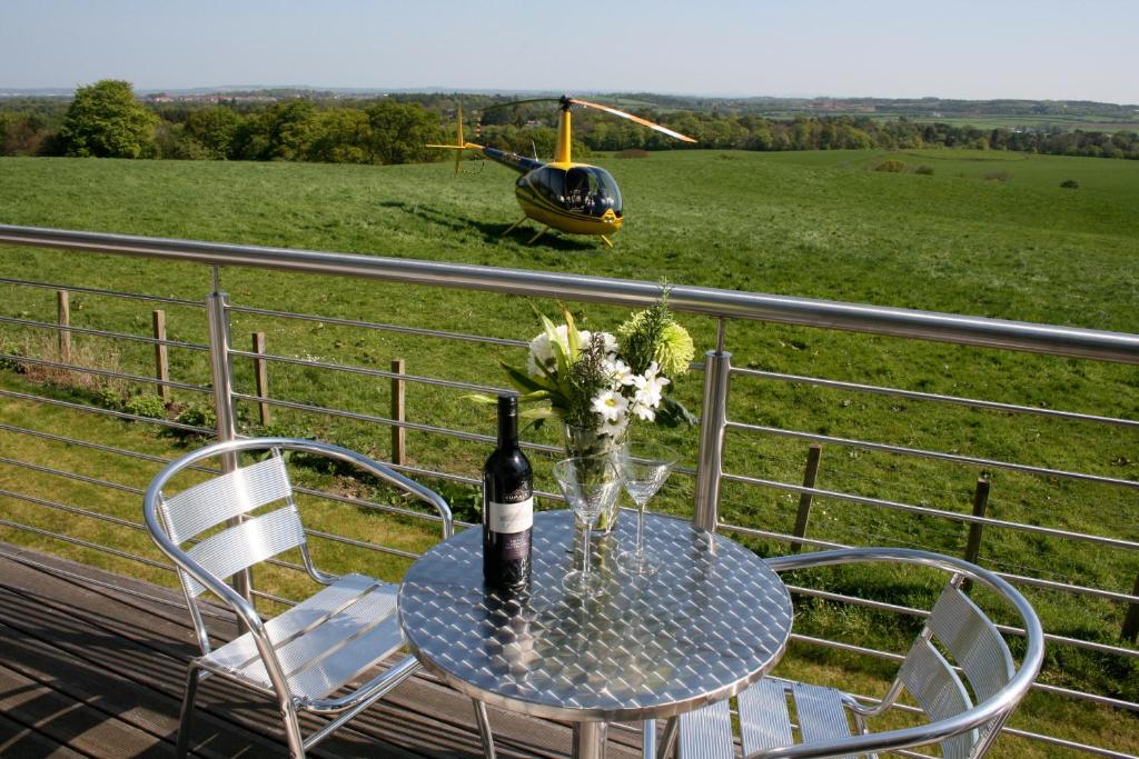 a table with a bottle of wine and a helicopter at Ayrs and Graces - Luxury Bed and Breakfast in Ayr