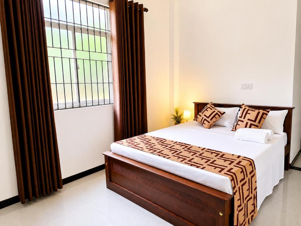 a bedroom with a bed and a large window at Air Route Transit in Seeduwa