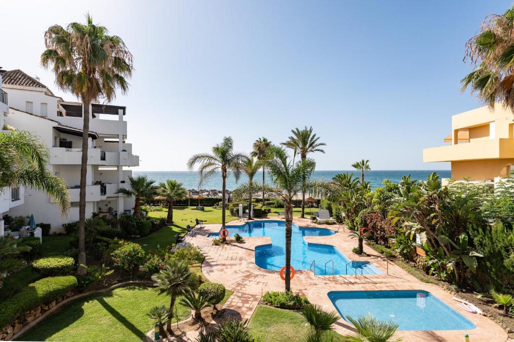 an aerial view of a resort with a pool and palm trees at 203 Arruzafa Sea View in Málaga