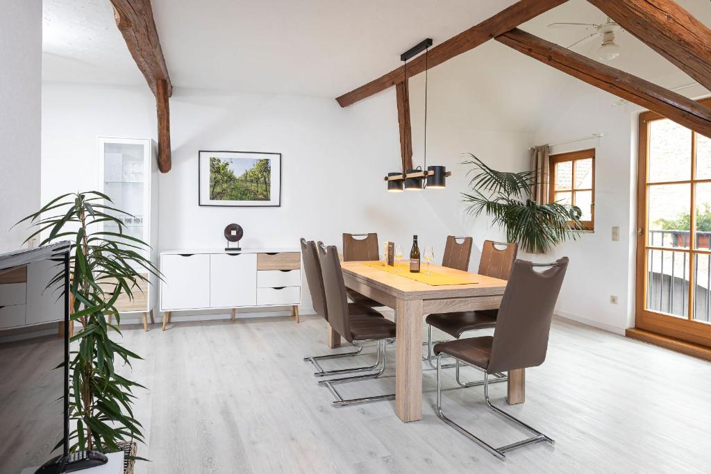 a dining room with a wooden table and chairs at Winzerhof Nagel in Dettelbach