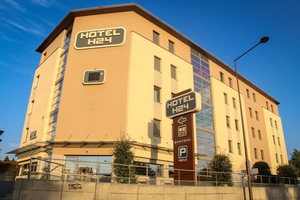 una señal de hotel frente a un edificio en H24 HOTEL, en Le Mans