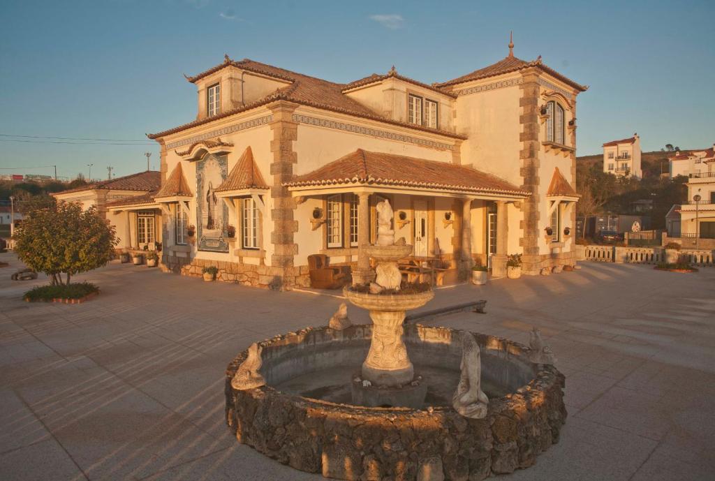 a large building with a fountain in front of it at Casa Branca in Ericeira