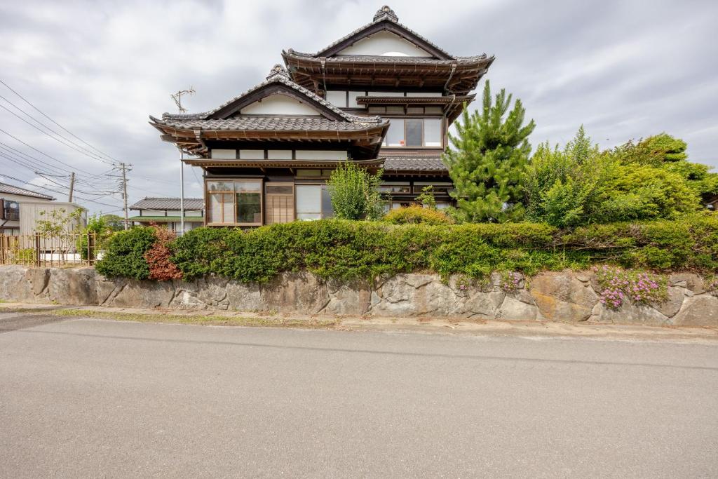 a building on the side of a road with a street at ジャポニークハウス in Sanmu