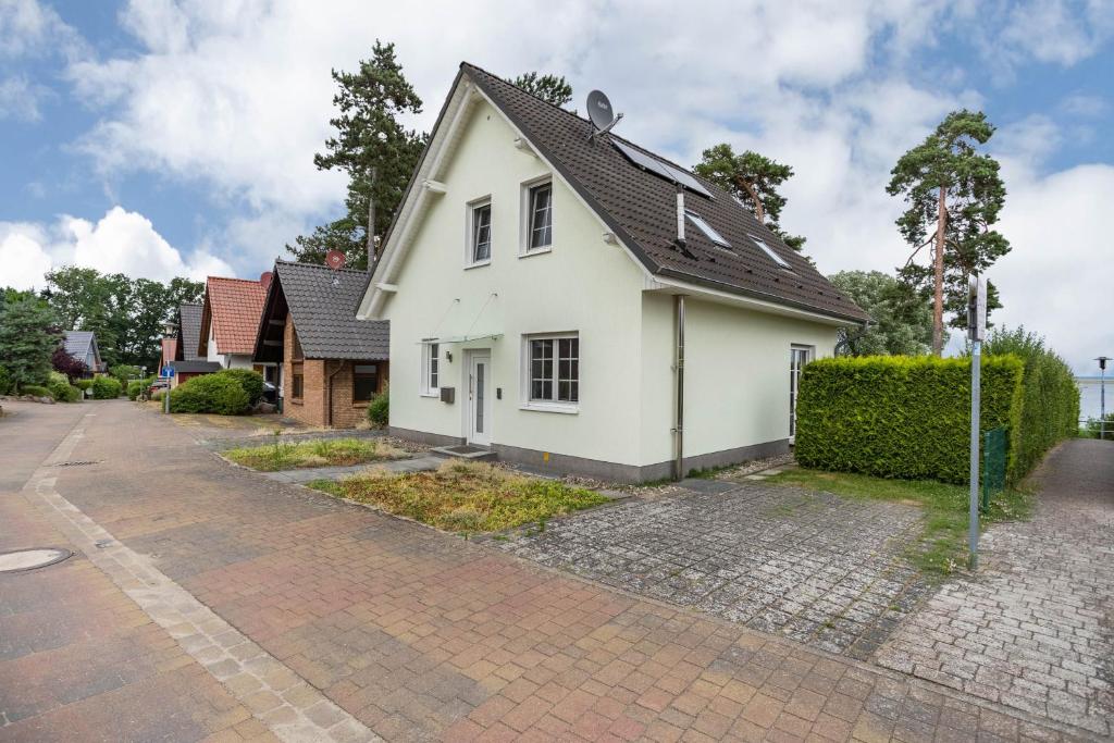 a white house with a black roof at Haus 7 in Röbel