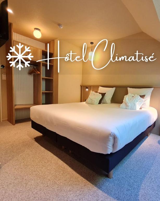 a bedroom with a large bed with a sign that reads hotel climate at Brit Hotel Confort Alençon in Alençon
