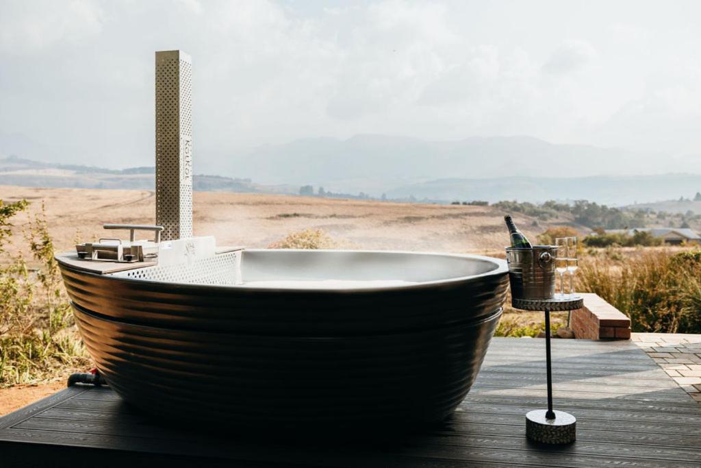 a large wooden bath tub sitting on a wooden deck at 2 Zebra View, Cathkin Estate in Winterton