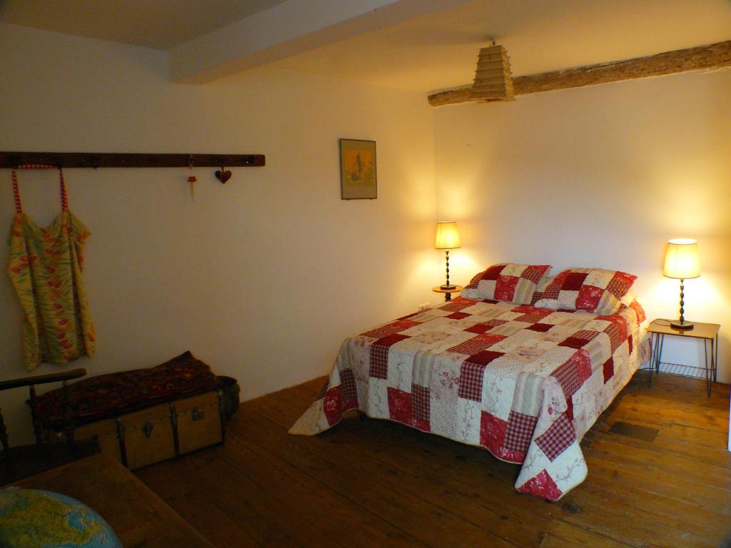 a bedroom with a bed with a checkered blanket at Nidélice Chambre d'hôtes in Quillan