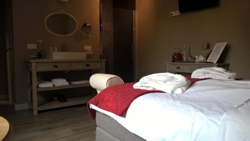 een slaapkamer met een bed met een wastafel en een spiegel bij B&B Rosteline in Hamont