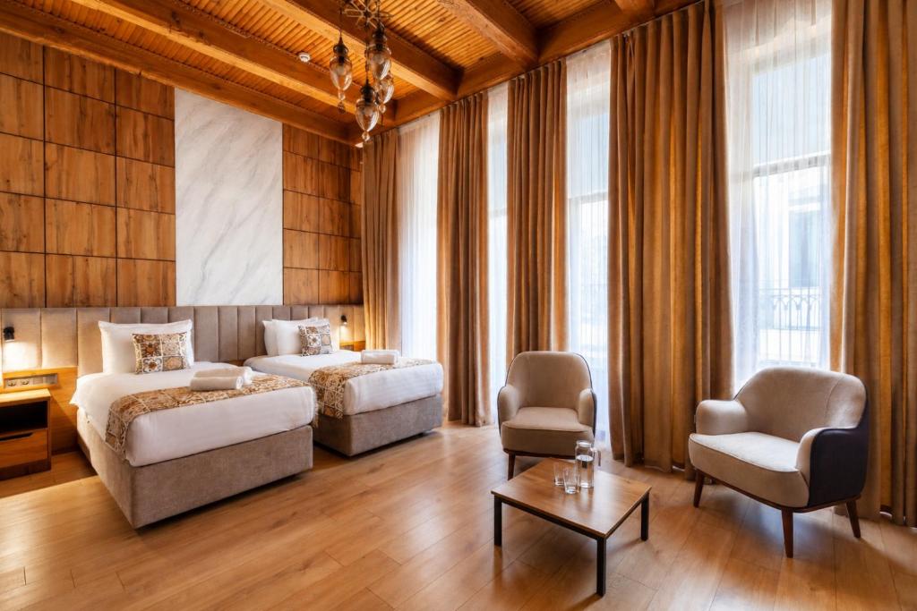 a bedroom with a bed and a couch and a table at Khan Hotel Bukhara Old Town in Bukhara