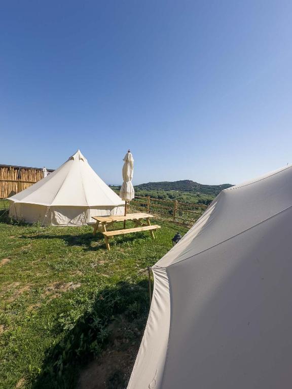 a large white tent in a field with a table at Wild Cretan West in Drakiana