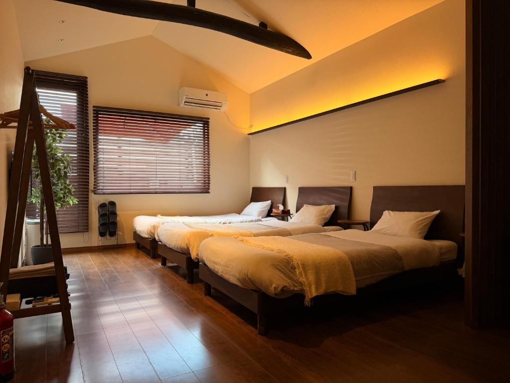a bedroom with three beds in a room at ura Kyunoju in Okayama