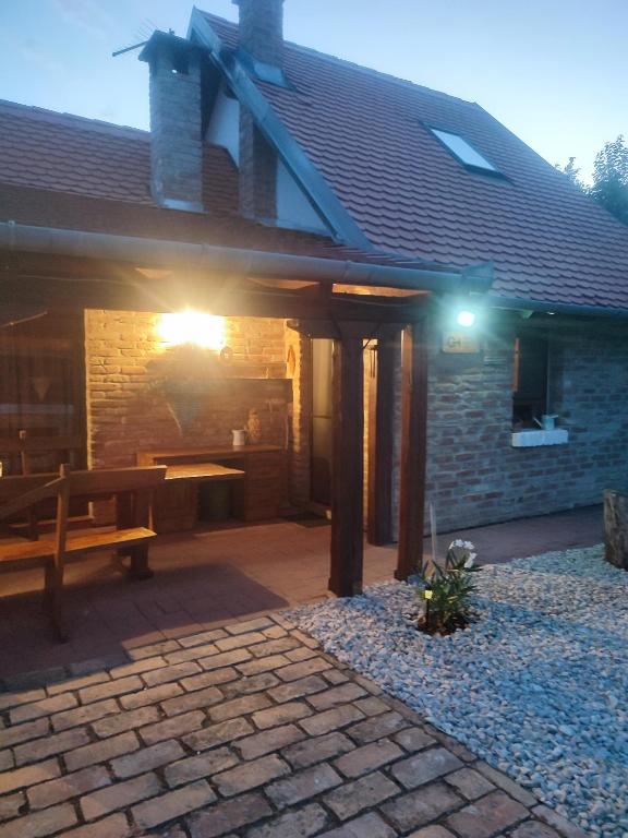 a house with a patio with a bench and a table at Glas house Aljmaš in Aljmaš