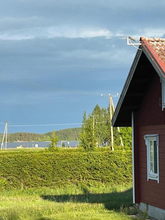 a red house with a field in the background at Lomakivi in Kausala