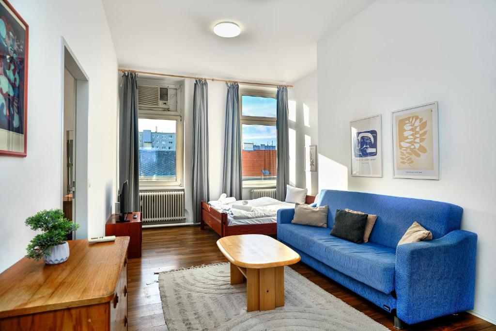 a living room with a blue couch and a table at 2 bedrooms & free parking in Vienna