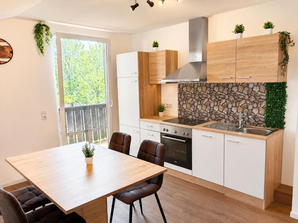 a kitchen with a wooden table and a dining room at Haus Martha in Hörbranz