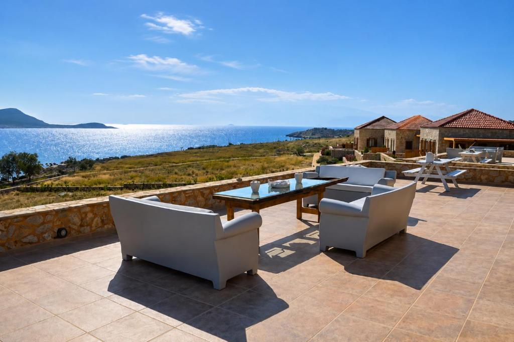 a patio with a table and chairs and the ocean at Villa Aristoteles in Halki