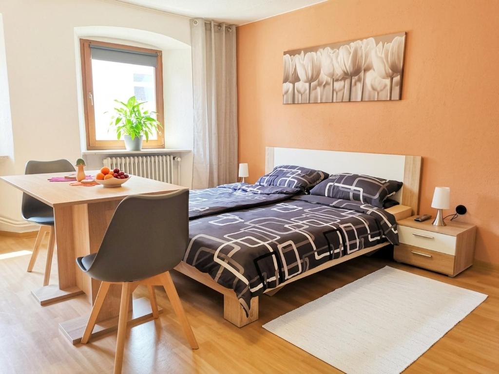 a bedroom with a bed and a table and a table and chairs at Pension am Kirchberg - Zimmer 1 in Daun