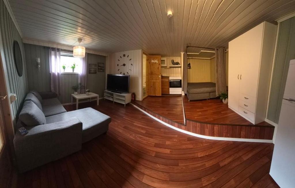 a living room with a couch and a wooden floor at Sweet home in Kristiansund