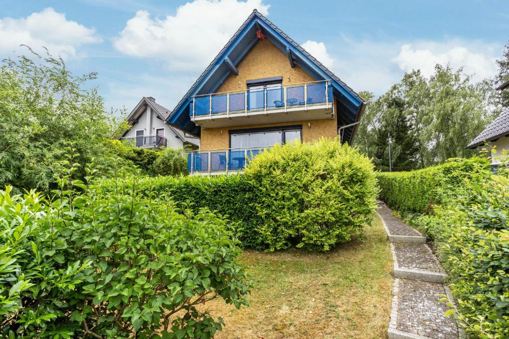 a house with a blue roof and bushes at Haus S 42 in Röbel
