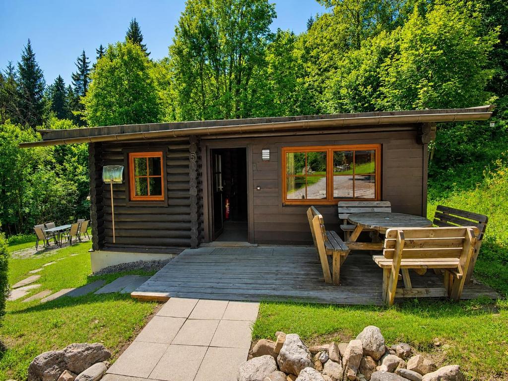 a cabin with a wooden deck and a table and chairs at Chalet in Wörgl near Ski Lift in Hopfgarten im Brixental