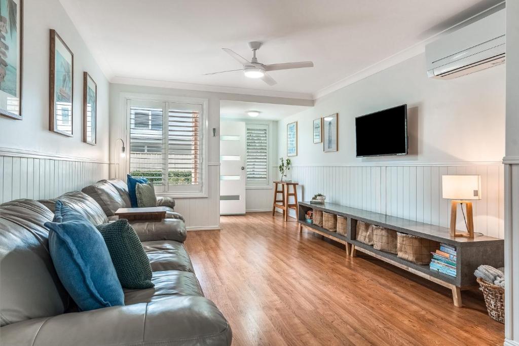 a living room with a couch and a flat screen tv at 1-41 Park Street in Evans Head