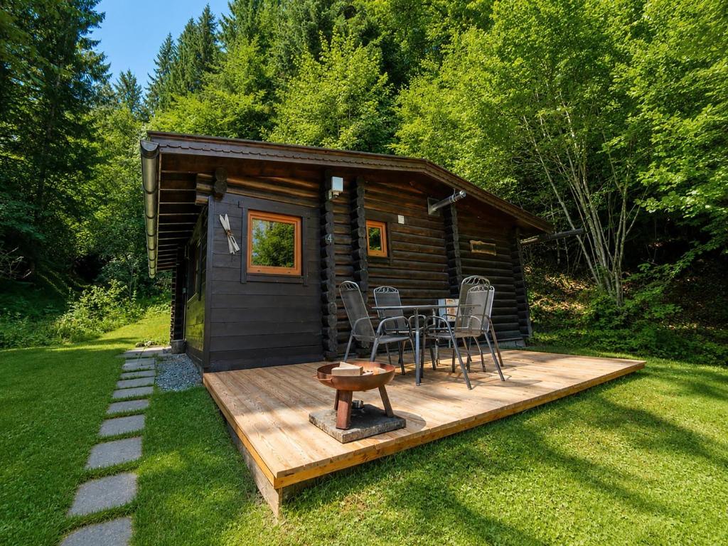 a cabin with a table and chairs on a deck at Rustic chalet near SkiWelt Wilder Kaiser in Salvenberg