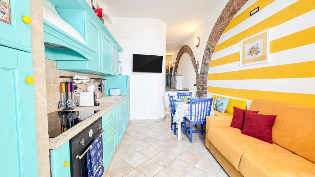 a kitchen with blue cabinets and a couch in a room at Sky & Sea, Terre Marine in Volastra