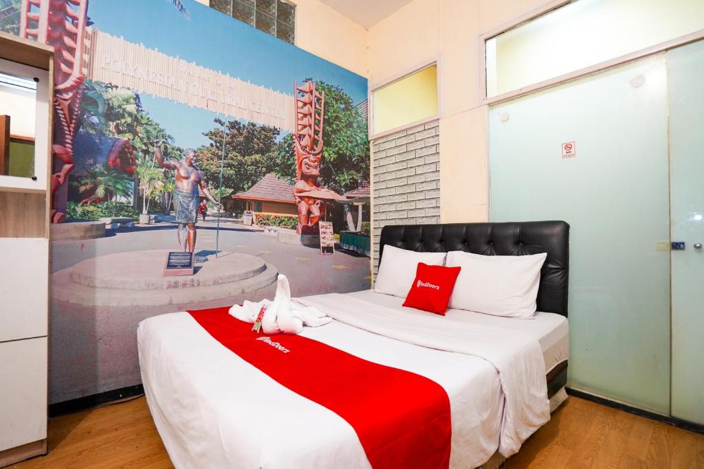 a bedroom with a bed with a red and white blanket at RedDoorz at Gangnam Hotel near Mall Olympic Garden in Betek