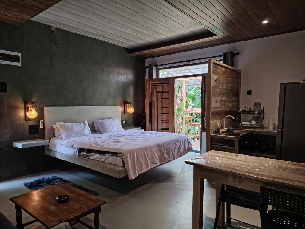 a bedroom with a bed and a table in it at Dothalu Villa in Ahangama