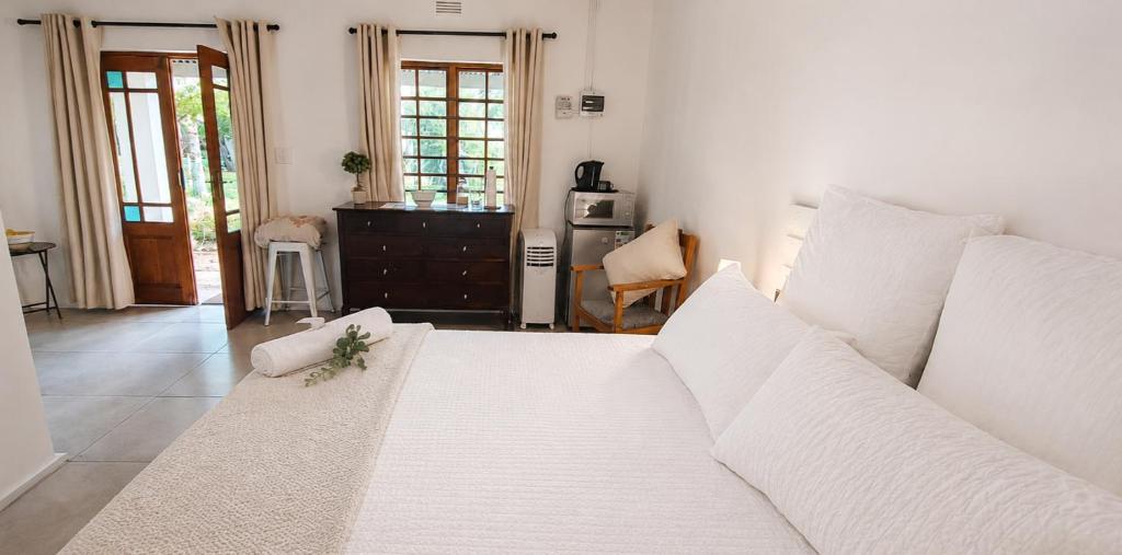 a living room with a white couch and a kitchen at Cedar Stay Clanwilliam in Clanwilliam