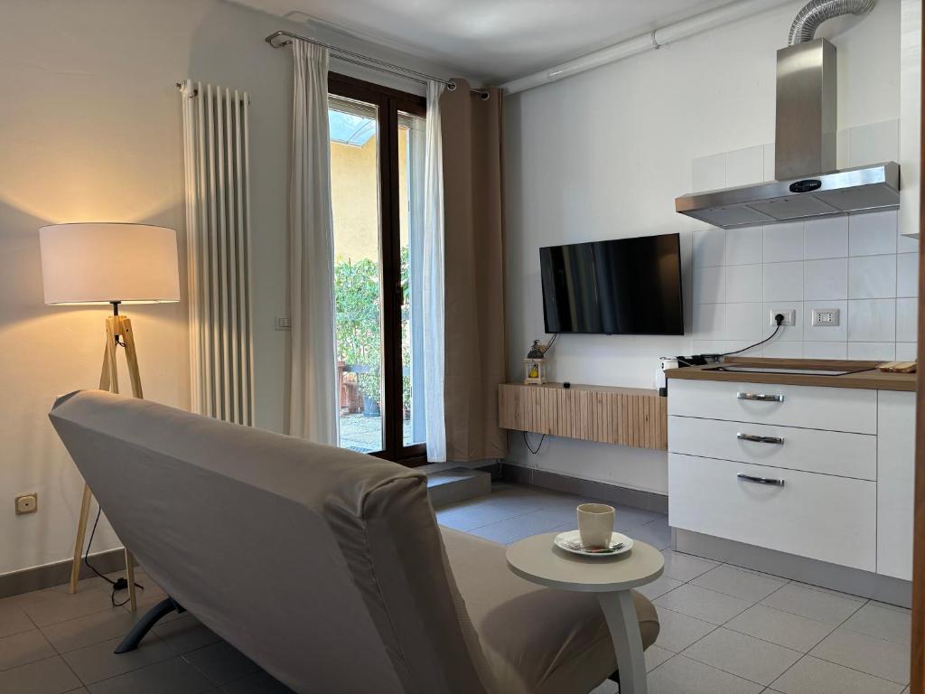 a kitchen with a chair and a table and a tv at Suite Terrazza Mazzini in Molinella