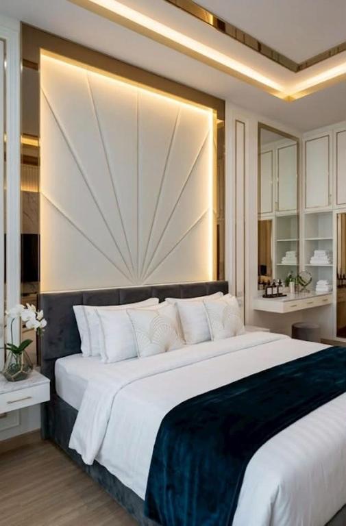 a bedroom with a large bed with a large headboard at Roi Et Residence Hotel in Roi Et